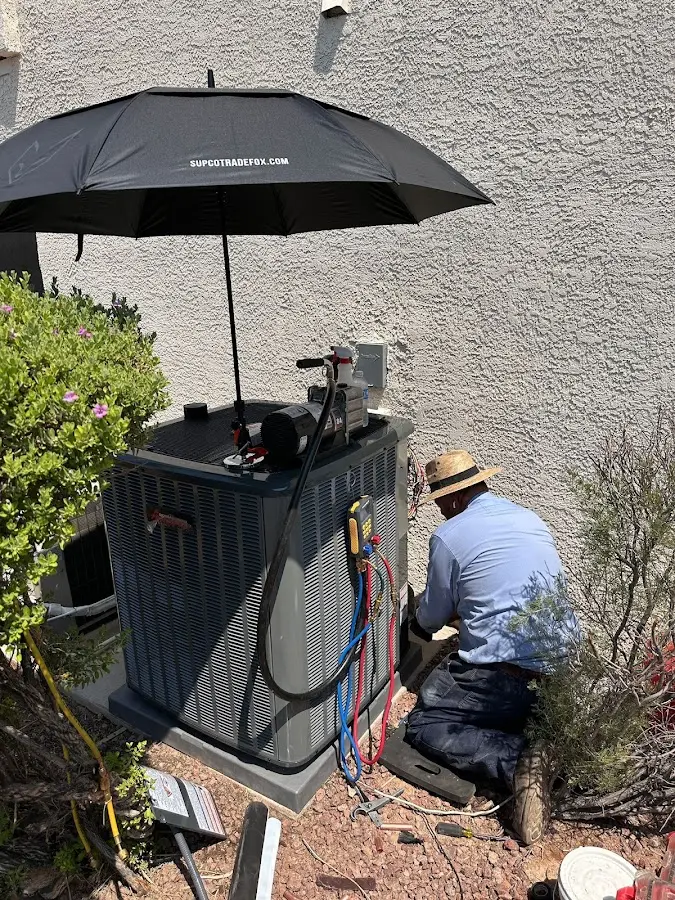 HVAC technician performing outdoor AC maintenance in Florence-Graham