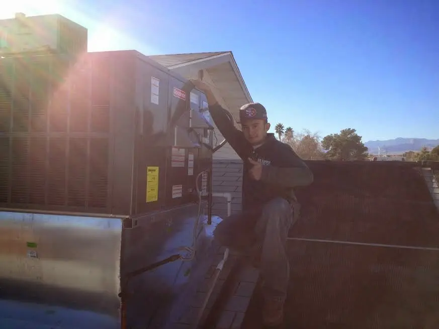 HVAC technician performing Air Duct Cleaning on a rooftop unit in Florence-Graham